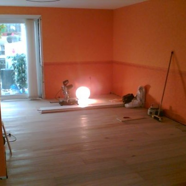 Haus- und Renovierungsservice: Parkett verlegt und Wohnzimmer tapeziert.